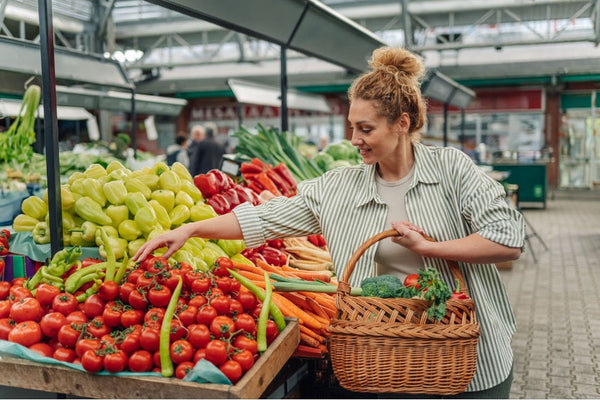 A person shopping for vegetables at a farmer’s market.