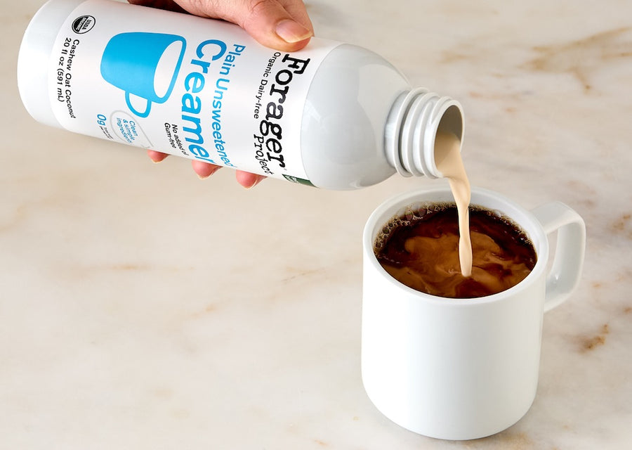Forager Project Unsweetened Creamer being poured into a mug of coffee on a marble surface