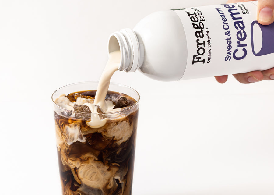 Forager Creamy Sweet & Creamy product being poured into a glass of iced coffee.