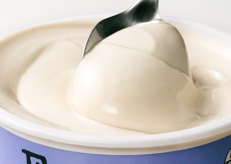 Spoon scooping yogurt from a container 