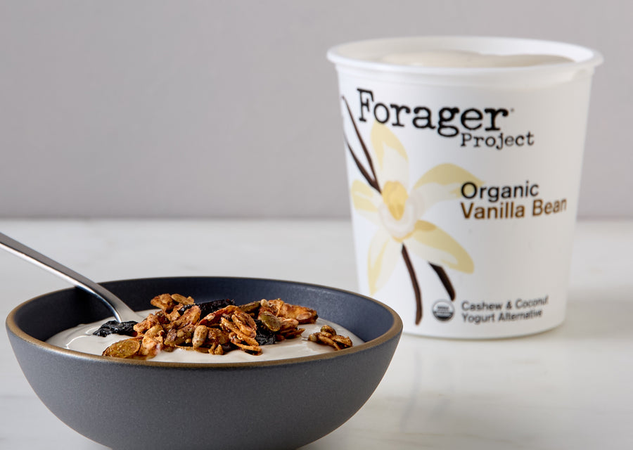 Forager Project Organic Vanilla Bean Yogurt next to a bowl of yogurt with granola and berries.