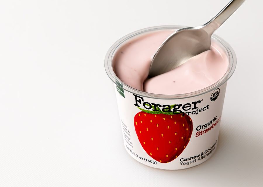 Forager Project Organic Strawberry Cashew & Coconut Yogurt Alternative with a spoon inside on a white background