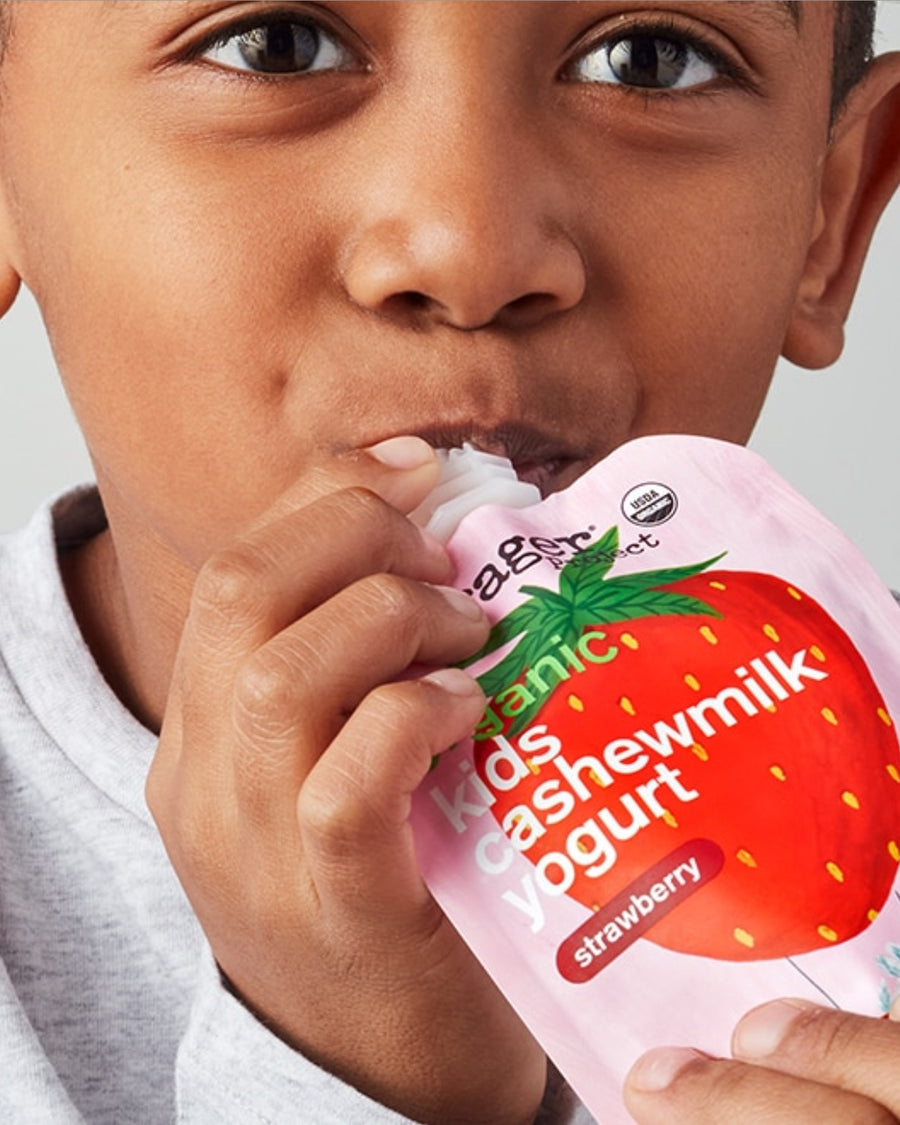 Child eating a strawberry-flavored kids' cashewmilk yogurt pouch