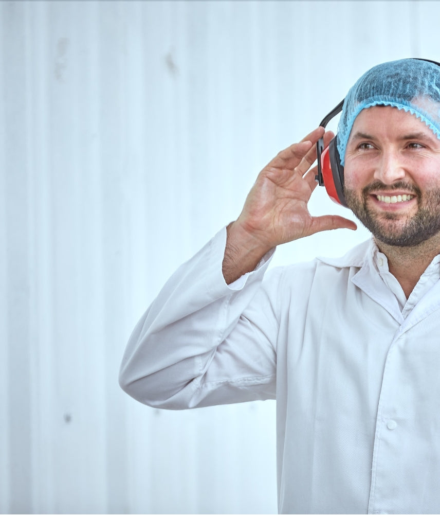 Person wearing ear protection with colleagues in a laboratory setting