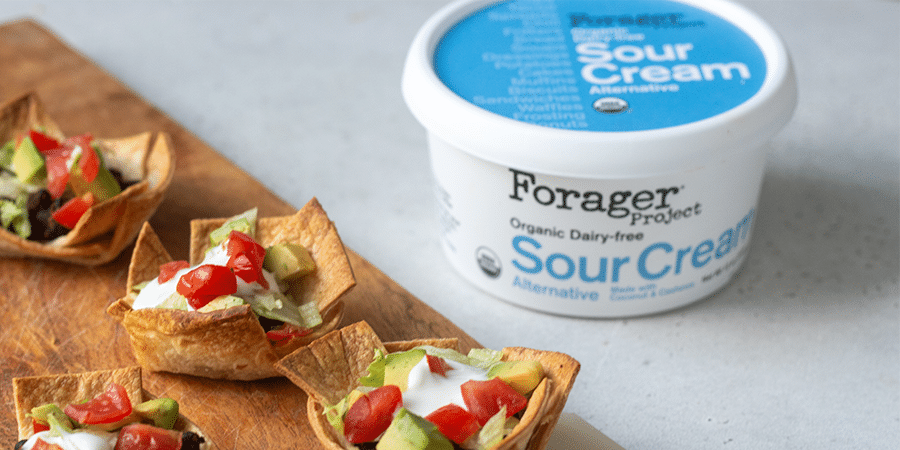 Mini tortilla cups next to a tub of Forager Project Sour Cream.