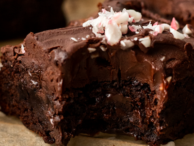 Close up of a moist vegan chocolate peppermint brownie with a bite out of it.