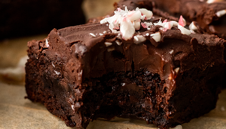 Close up of a moist vegan chocolate peppermint brownie with a bite out of it.