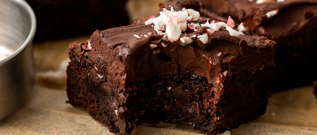 Close up of a moist vegan chocolate peppermint brownie with a bite out of it.